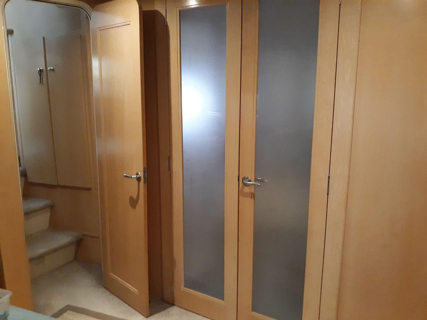 Master Stateroom shower, sink and toilet with doors closed for privacy. Door on left (forward) leads up to Salon. 