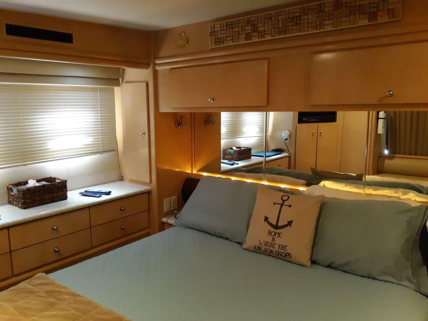 Master Stateroom. Mirrored and lit headboard with overhead storage. 