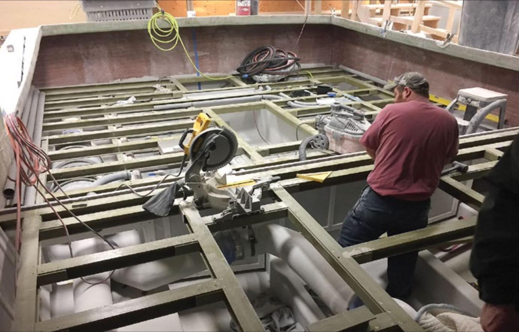 The support grid of beams and stringers prior to deck installation reveals the mechanical systems and ample tankage space below the broad, open cockpit.
